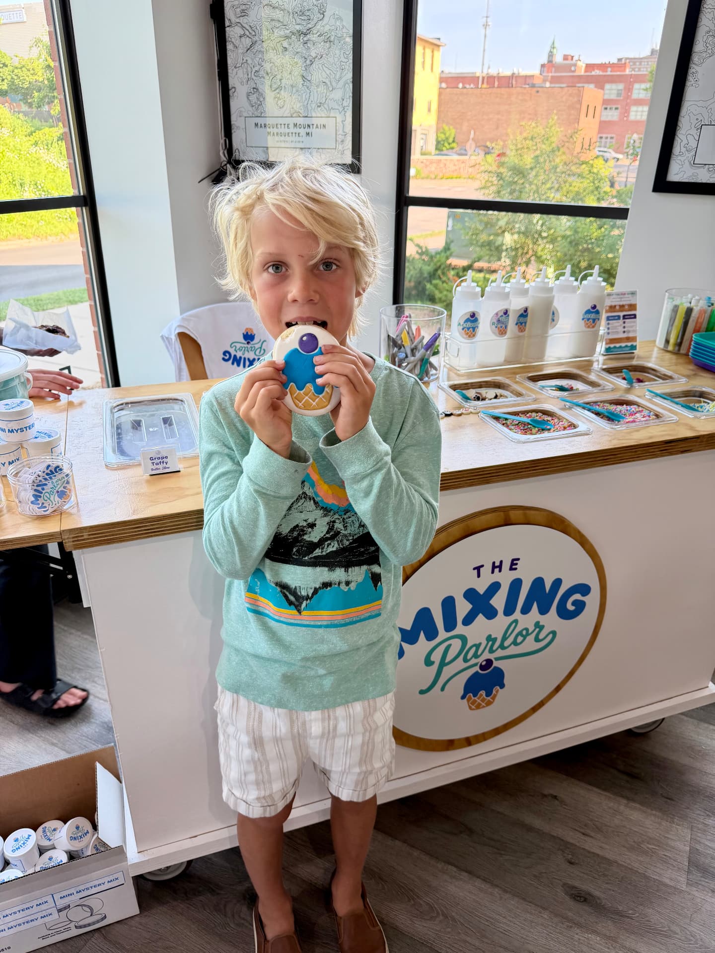 A young customer at The Mixing Parlor cart holding a decorated cookie