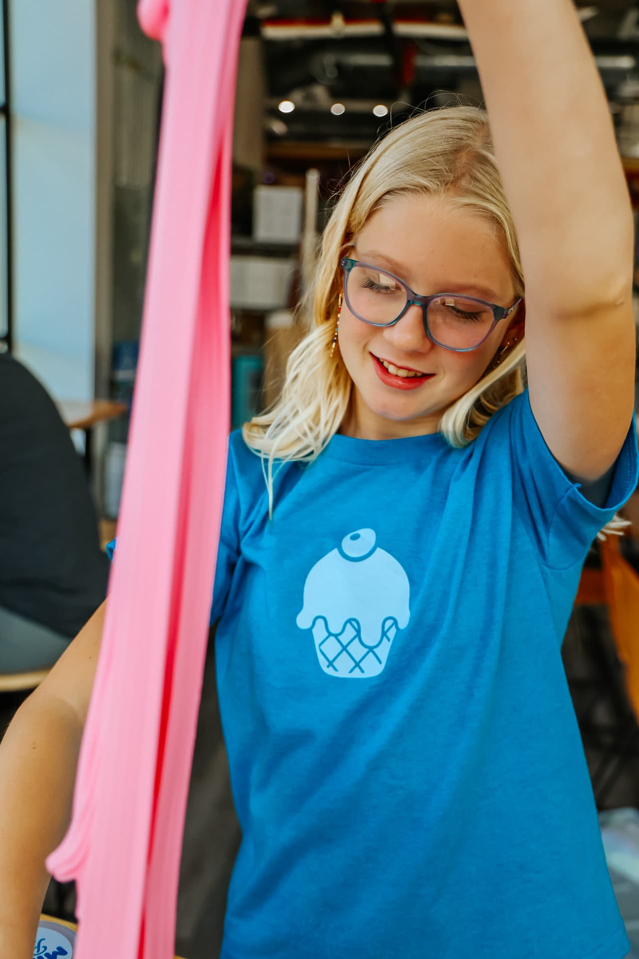 Aira, founder and CEO of The Mixing Parlor, stretching a long ribbon of pink slime above her head